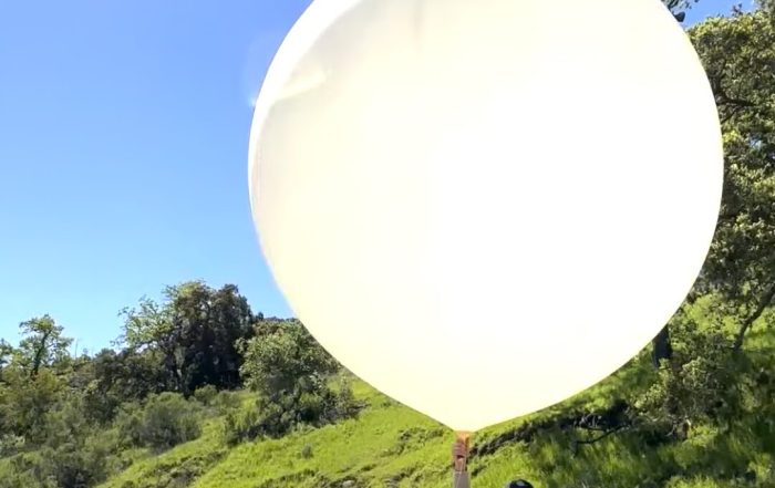 Luke Iseman holding a large balloon filled with sulfur dioxide