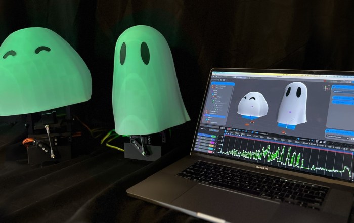 Glowing 3D-printed ghosts on animatronic controllers, next to a laptop running free motion control software